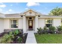Inviting entryway with a dark wood door, manicured landscaping and decorative stone accents at 9957 Sw 45Th Ave, Ocala, FL 34476