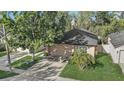 Aerial view of tan home with two-car garage, driveway, a small palm tree and nice landscaping at 125 Placid Woods Ct, Sanford, FL 32773