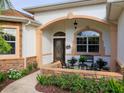 Welcoming front porch with seating area, stone accents, and a beautiful front door, offering great curb appeal at 1953 Hartford Path, The Villages, FL 32162