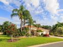 Beautiful single-story home features lush landscaping, palm trees, and well-maintained lawn, creating a tropical paradise at 1953 Hartford Path, The Villages, FL 32162