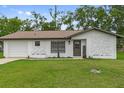Charming single-story home features a welcoming facade, attached garage and a well-manicured lawn at 21191 Sw Plantation St, Dunnellon, FL 34431