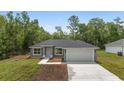 Charming single-story home boasts a two-car garage and simple landscaping at 2297 Sw 143 Ct, Ocala, FL 34481