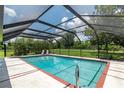 Enclosed pool featuring a clear blue pool, surrounded by a screened enclosure and lush greenery at 2640 Sw 36Th Ln, Ocala, FL 34471