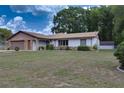 Lovely one-story house displaying a stone facade, attached garage, and manicured landscaping at 3427 Se 137Th St, Summerfield, FL 34491