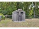 Backyard storage shed with solar panels and double doors, set within a fenced yard at 3427 Se 137Th St, Summerfield, FL 34491