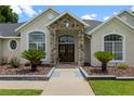 Close-up of the front entry, highlighting the stone pillars and beautiful wood double doors at 3883 Se 51St Ct, Ocala, FL 34480