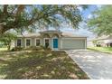 Charming single-story home with a well-manicured lawn, inviting blue door, and attached two-car garage at 4531 Se 27Th St, Ocala, FL 34480