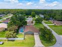 Aerial view of a home featuring a screened-in pool and a well-manicured lawn in a quiet residential neighborhood at 5390 Se 15Th Ct, Ocala, FL 34480