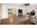 Spacious living room featuring hardwood floors, a ceiling fan, and an ornate fireplace at 6495 Sw 109Th St, Ocala, FL 34476