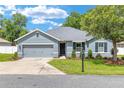 Beautiful single-story home with a well-maintained lawn, complemented by mature trees and landscaping at 7054 Sw 64Th Ter, Ocala, FL 34476