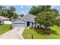 Charming single-story home featuring a well-manicured lawn and an attached two-car garage at 7054 Sw 64Th Ter, Ocala, FL 34476
