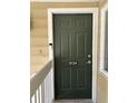View of the front door of the condo featuring the unit number, a peephole, and white trim at 8134 Fairways Cir # R203, Ocala, FL 34472