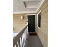 Condo entryway featuring the unit door, natural lighting, and durable exterior siding at 8134 Fairways Cir # R203, Ocala, FL 34472