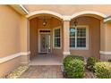 Inviting front porch with decorative columns, hanging lanterns, and a beautifully designed front door at 8380 Sw 82Nd Cir, Ocala, FL 34481
