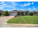 Inviting single-story home with manicured lawn, fresh landscaping, and brick paved driveway at 8640 Sw 83Rd Loop, Ocala, FL 34481