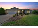 Charming single-story home featuring a well-manicured lawn and a brick-paved driveway at sunset at 8640 Sw 83Rd Loop, Ocala, FL 34481