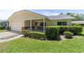 Well-maintained home featuring manicured landscaping, a covered porch, and an attached garage at 8704 Sw 94Th Ln # G, Ocala, FL 34481