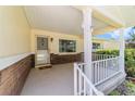 Inviting covered front porch with white railings and security features at the home's entry at 8704 Sw 94Th Ln # G, Ocala, FL 34481