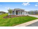 Landscaped single-story home with a three-car garage, patterned brick driveway, and a well-manicured lawn at 10026 Sw 85Th Place Rd, Ocala, FL 34481