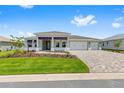 Well-maintained single-story home boasts a three-car garage, patterned brick driveway, and an inviting front lawn at 10026 Sw 85Th Place Rd, Ocala, FL 34481