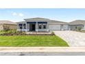A beautiful home with a well-manicured lawn and long paver driveway at 10045 Sw 82Nd Place Rd, Ocala, FL 34481