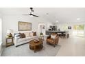 Open concept living room with modern furnishings, kitchen access, and a light, bright atmosphere at 1083 Sw Winding Hills Rd, Dunnellon, FL 34431