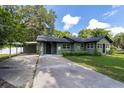 View of a lovely single-story home with a covered carport and a well-maintained front lawn and garden at 11430 Se 54Th Ave, Belleview, FL 34420