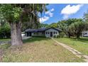 Charming single-story house with a well-kept lawn, mature trees, and a brick walkway leading to the front door at 11430 Se 54Th Ave, Belleview, FL 34420