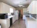 Bright kitchen with white cabinetry, backsplash, and modern appliances providing ample counter space at 11470 Sw 139Th St, Dunnellon, FL 34432