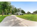 Long driveway leading to a home with a detached garage and carport at 12681 Se 54Th Ave, Belleview, FL 34420