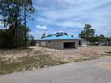 Unfinished concrete block home with blue roofing being built in a sunny, undeveloped neighborhood at 13322 Sw 85 Cir, Ocala, FL 34473