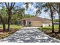 Inviting single-story home with a long driveway, neat landscaping, and mature trees at 13741 Sw 73Rd St, Ocala, FL 34481