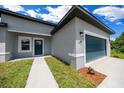 Close-up of a single-story house with a blue front door, garage, and well-maintained landscaping at 13780 Sw 42Nd Court Rd, Ocala, FL 34473