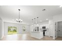Bright, open-concept living area with sleek flooring, modern lighting, and sliding glass doors at 13780 Sw 42Nd Court Rd, Ocala, FL 34473