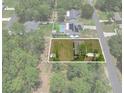 Aerial view of a property showcasing the house, lawn, and surrounding wooded area at 15138 Sw 50Th Avenue Rd, Ocala, FL 34473