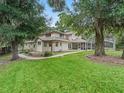 Spacious backyard with lush trees and a pristine screened pool at 1630 Se 29Th Ter, Ocala, FL 34471