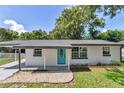 A charming home featuring a bright blue front door, complemented by well-maintained landscaping and a welcoming entrance at 1636 Sw 5Th Pl, Ocala, FL 34471