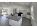 Modern kitchen with granite countertops, white cabinetry, and stainless steel appliances at 1780 Winding Hills Rd, Dunnellon, FL 34431