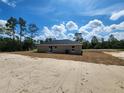 Image showing the rear of the property with fresh new sod and covered patio at 1780 Winding Hills Rd, Dunnellon, FL 34431