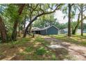 Exterior of charming home featuring a blue exterior, lush landscaping, and mature trees for added privacy at 1841 Ne 38Th St, Ocala, FL 34479