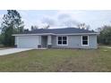 Single-story home featuring a two-car garage, stone accents, and a well-maintained lawn at 20154 Sw Rainbow Lakes Blvd, Dunnellon, FL 34431