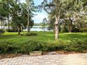 Expansive backyard featuring mature trees, a well-maintained lawn, and a serene lake view at 2131 Ne 145Th Avenue Rd, Silver Springs, FL 34488