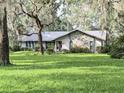 Charming single-story home featuring stone accents and a well-manicured lawn at 2131 Ne 145Th Avenue Rd, Silver Springs, FL 34488