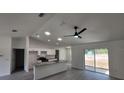 Bright, open-concept living room with sliding doors, a ceiling fan and a kitchen island at 23213 Nw Mallard Ave, Dunnellon, FL 34431