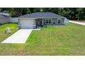 Charming single-story home with a well-manicured lawn and attached two-car garage, perfect for suburban living at 3094 Se 144Th Pl, Summerfield, FL 34491