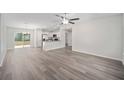 Expansive living area featuring sleek flooring, bright neutral walls, and seamless transition to kitchen at 3248 Sw 149Th Pl, Ocala, FL 34481
