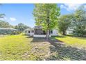 A beautiful home's backyard is shaded by a large tree and features a screened-in porch for outdoor enjoyment at 3428 Ne 17Th Ter, Ocala, FL 34479