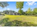 Expansive backyard with a screened-in porch and mature trees, perfect for outdoor activities and relaxation at 3428 Ne 17Th Ter, Ocala, FL 34479