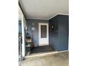 Cozy covered porch with a white front door, a small shelving unit, and neutral-toned walls for a welcoming entrance at 3709 Ne 4Th St, Ocala, FL 34470