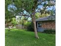 Cozy home with a brick facade, lush lawn, and beautiful landscaping, including blooming rose bushes at 3709 Ne 4Th St, Ocala, FL 34470